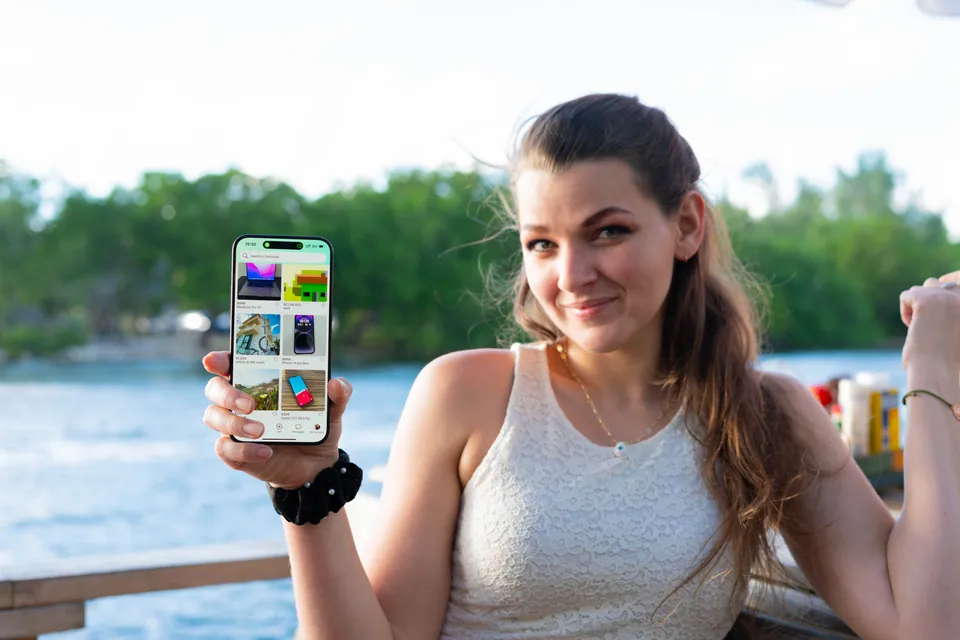 Una mujer sostiene un teléfono con anuncios de la app de Zerobolas